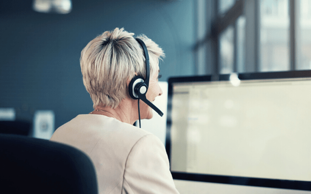 blonde woman working in a call centre, speaking to customers about disaster recovery services